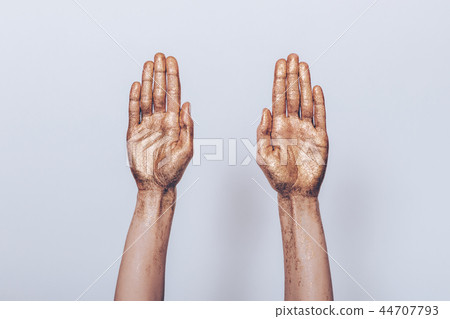 Woman's both hands painted golden sequins showing 44707793