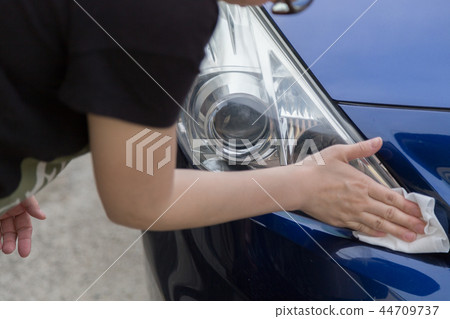 Woman brushing car headlights Woman brushing car headlights 44709737