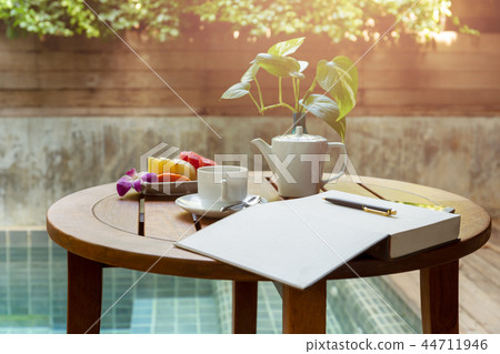 Selected focus cup of coffee and open notebook with pen on the wooden table. 44711946
