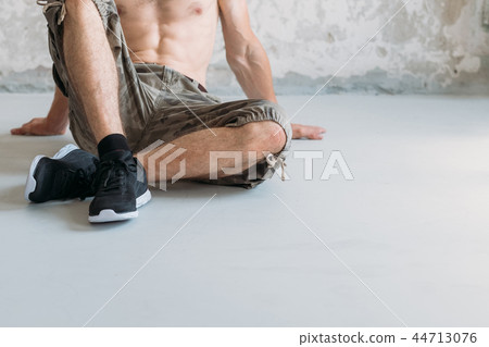 athletic lifestyle man sit gym floor bare chested 44713076