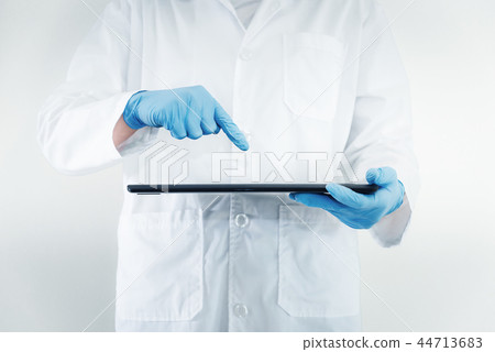 Closeup of female medical doctor is using tablet 44713683
