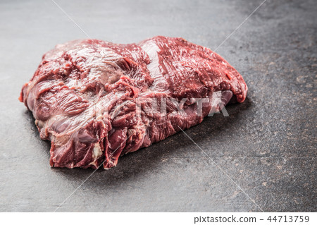 Portion of raw beef neck on dark butcher board Portion of raw beef neck on dark butcher board 44713759