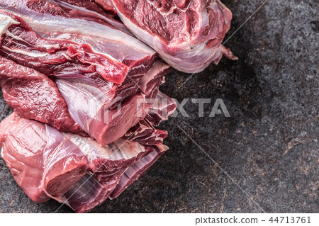 Portion of raw beef shank on dark butcher board 44713761