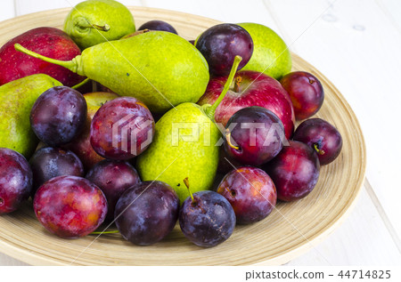 Ripe fruit on wooden plate 44714825
