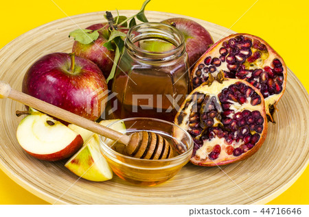 Rosh hashanah (jewish holiday) concept. Honey, apple and pomegranate on wooden dish Rosh hashanah (jewish holiday) concept. Honey, apple and pomegranate on wooden dish 44716646