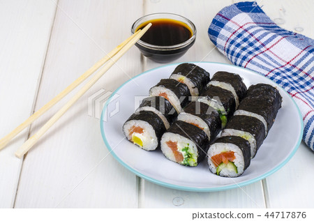 Rolls with salmon, plate on wooden table Rolls with salmon, plate on wooden table 44717876