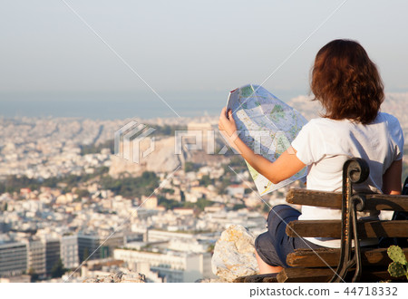 woman with a map sitting on Lycabettus Hill woman with a map sitting on Lycabettus Hill 44718332