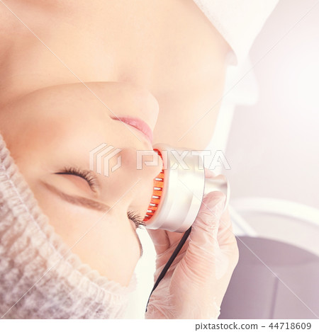 Woman cosmetology procedure. Light face treatment 44718609