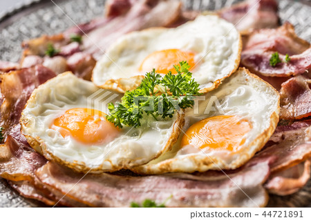 Close-up roasted bacon and egg with herbs. Close-up roasted bacon and egg with herbs. 44721891