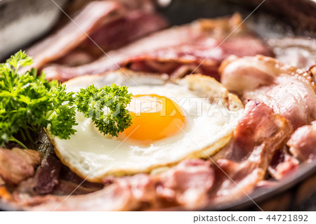 Close-up roasted bacon and egg with herbs. Close-up roasted bacon and egg with herbs. 44721892