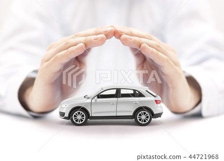 Car insurance. Small silver car covered by hands. 44721968