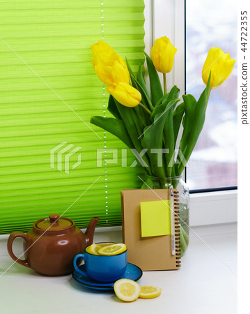 Yellow tulips and tea with lemon 44722355