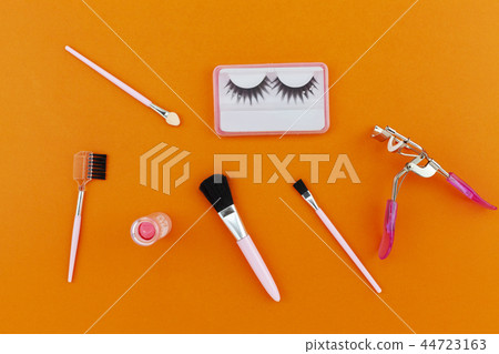 Cosmetics set for women isolated on orange paper Cosmetics set for women isolated on orange paper 44723163