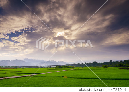 太陽穿過雲層形成傾斜的光在山頂上。 44723944