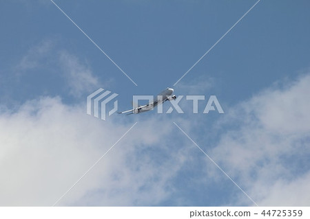 Boeing 747-400 jumbo jet airliner flying through clouds of calm blue sky 44725359