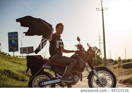 A motorbiker on the bikde waving hos jacket A motorbiker on the bikde waving hos jacket 44725526