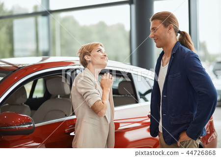 Happy young wife asking to buy a new car for her in the dealership. 44726868