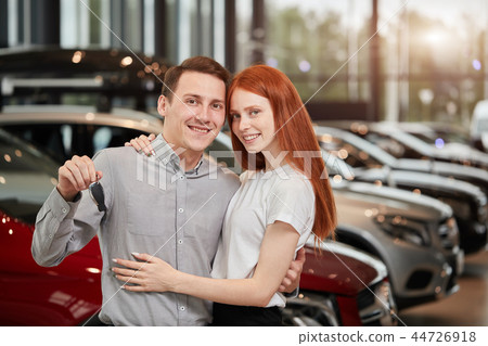 Beautiful couple is holding key of their new car, looking at camera and smiling 44726918