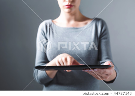 Young woman using her tablet Young woman using her tablet 44727143