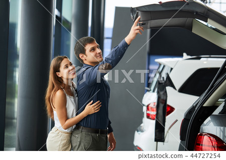 Loving smart couple choosing a car at the car dealership showroom 44727254
