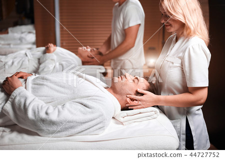 Man receiving back massage from masseur in spa Man receiving back massage from masseur in spa 44727752