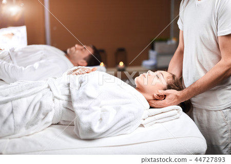 Beautiful young woman receiving massage on head and shoulders zone in spa centre Beautiful young woman receiving massage on head and shoulders zone in spa centre 44727893