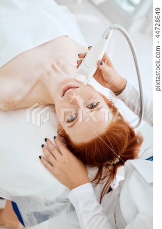 Woman getting rf-lifting in a beauty salon. Modern technologies in cosmetology. 44728649