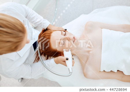 Woman getting rf-lifting in a beauty salon. Modern technologies in cosmetology. 44728694