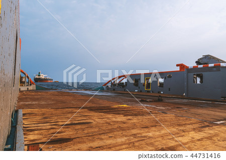 AHTS vessel doing static tow tanker lifting. Ocean tug job 44731416