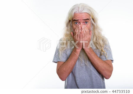 Studio shot of senior bearded man looking shocked while covering Studio shot of senior bearded man looking shocked while covering 44733510