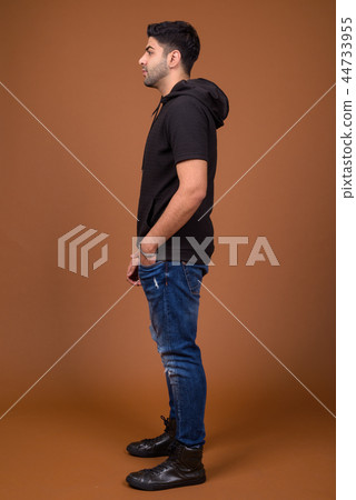 Young handsome Indian man against brown background Young handsome Indian man against brown background 44733955