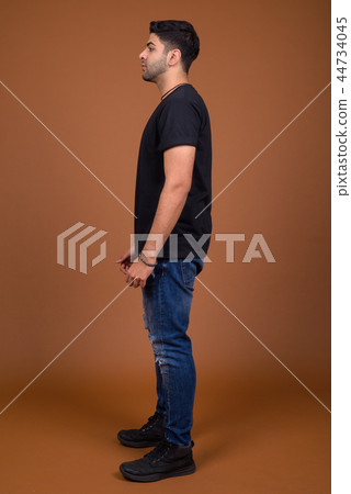 Young handsome Indian man against brown background Young handsome Indian man against brown background 44734045