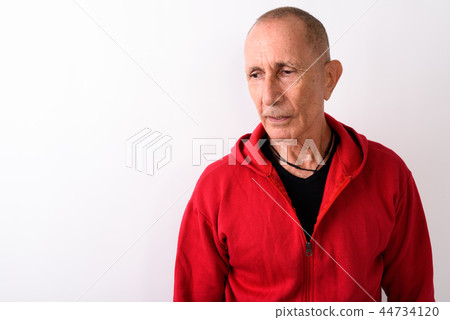 Close up of bald senior man thinking while looking sad against w 44734120