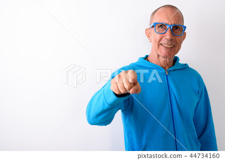 Studio shot of happy bald senior man smiling and pointing at cam Studio shot of happy bald senior man smiling and pointing at cam 44734160