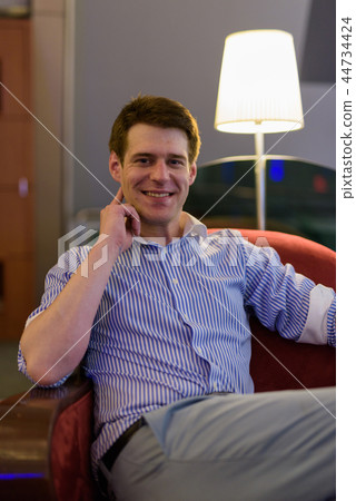 Young handsome businessman relaxing at the hotel lobby 44734424