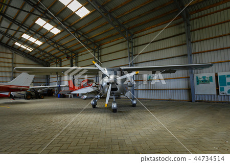 outdoor shot of small plane standing in shed 44734514