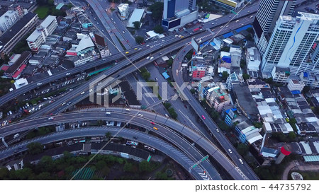 Cars driving on bridge roads shaped curve highways with skyscrap 44735792