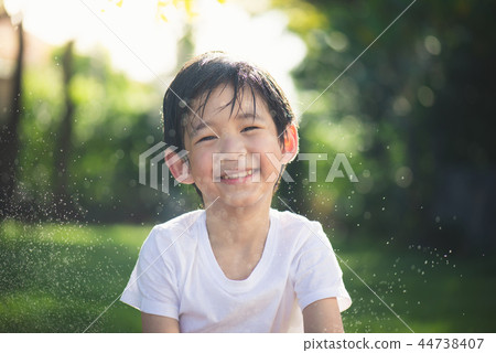 Cute asian boy has fun playing water in the garden 44738407