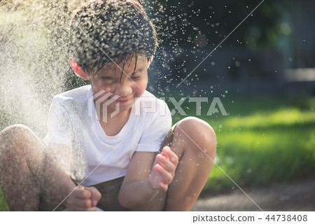 Cute asian boy has fun playing water in the garden 44738408