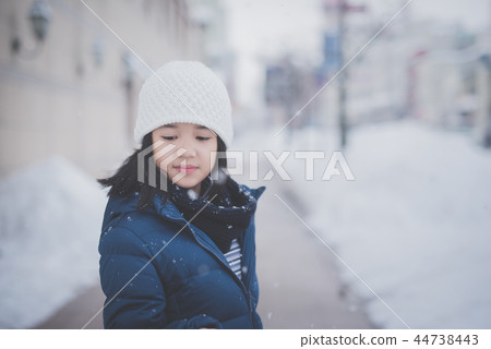 Asian girl enjoying snowfall Asian girl enjoying snowfall 44738443