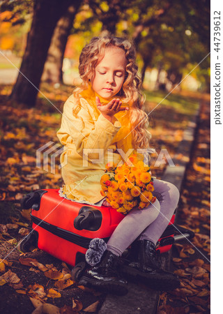 Little girl with blond hair in autumn background 44739612