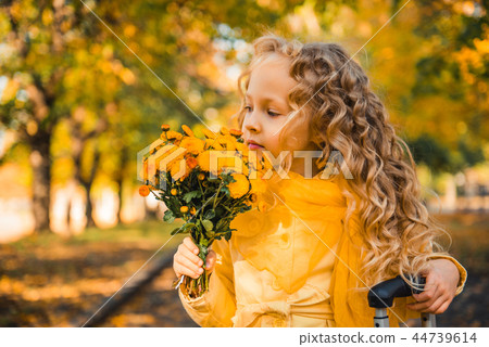 Little girl with blond hair in autumn background 44739614