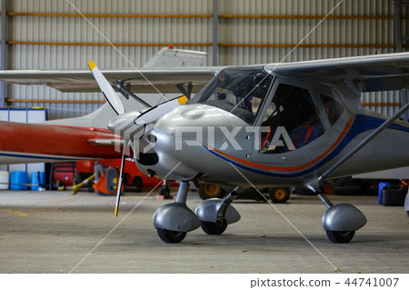 outdoor shot of small plane standing in shed 44741007