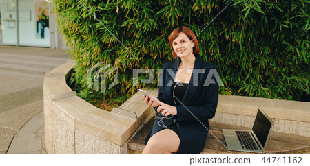 Secretary listening to music with in ear phones and smartphone o 44741162