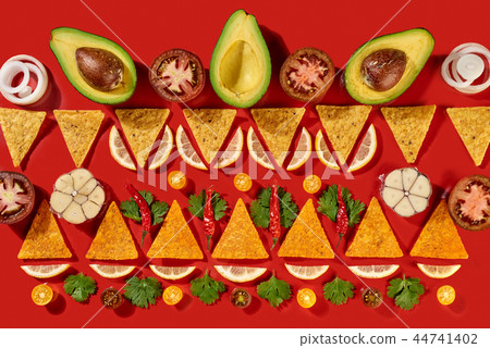 Creative geometric food pattern from mexican nachos corn chips, fresh vegetables, fruits, greens Creative geometric food pattern from mexican nachos corn chips, fresh vegetables, fruits, greens 44741402
