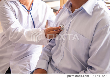 The doctor is listening to the patient's heart. The doctor is listening to the patient's heart. 44741848