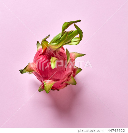 View from above to tropical fruit - pitahaya with green leaf on a pink background, copy space. Top 44742622