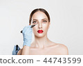 Doctor Hands drawing marks on female face 44743599