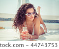 woman drinking champagne at the beach 44743753
