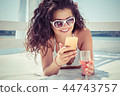 smiling woman texting on phone 44743757